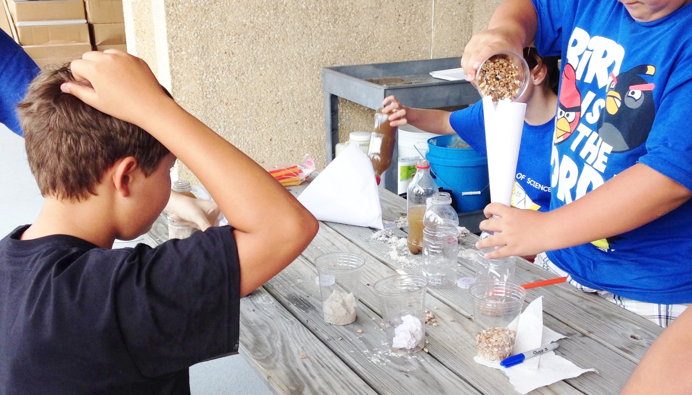 Campers at a VT camp make sand filters for water