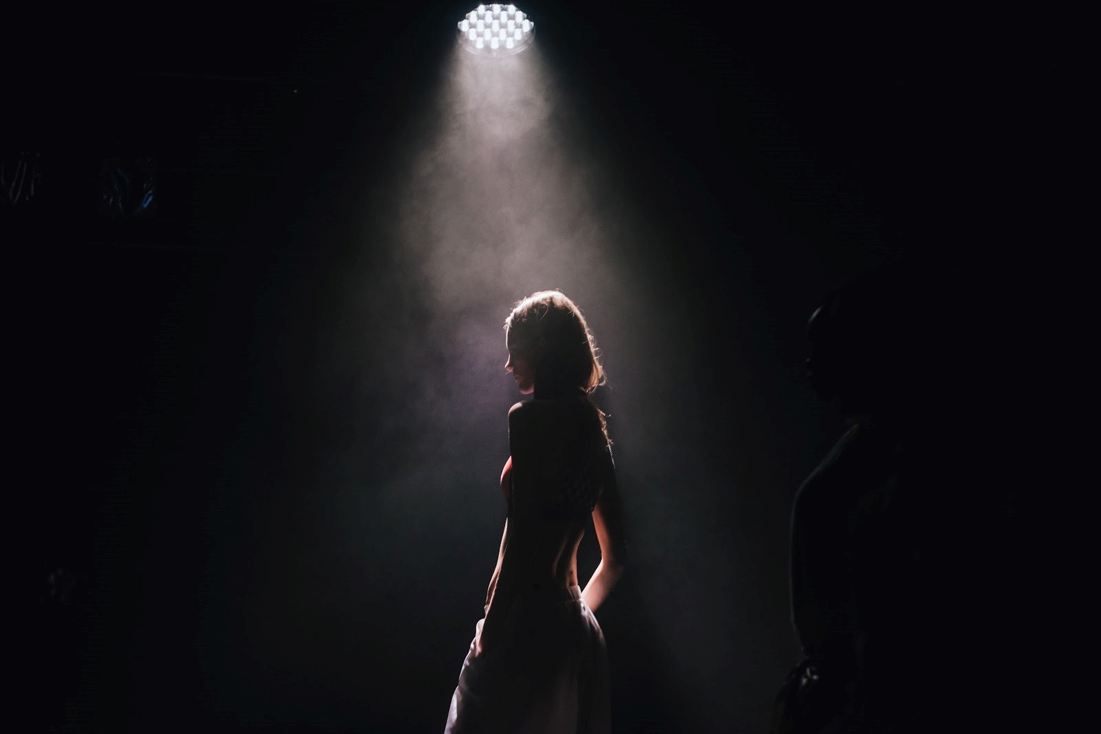 A woman in the spotlight on a stage
