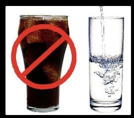 A glass of soda with a no sign on top next to a glass of water